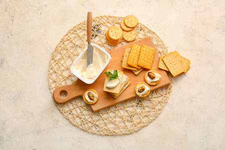Tasty crackers with cheese and mussels on grunge background
