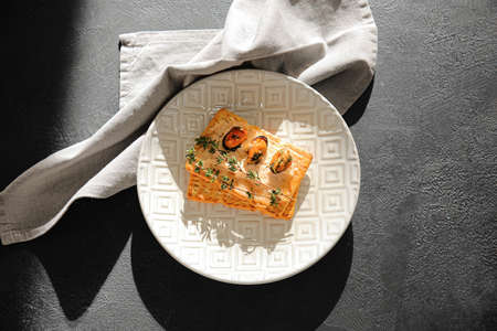 Plate with tasty crackers on dark backgroundの写真素材