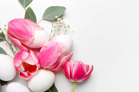 Beautiful Easter composition with eggs and spring flowers on white background