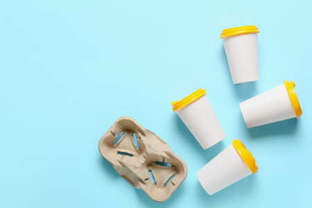 Takeaway cups for coffee on color background