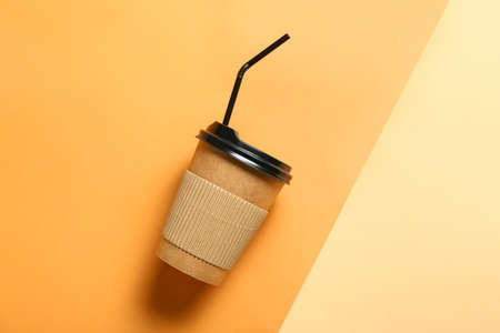 Takeaway cup for drink with straw on color background