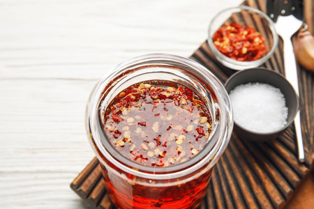 Composition with jar of hot honey on light wooden backgroundの写真素材