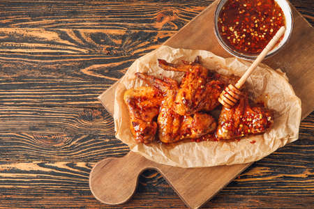 Tasty fried chicken wings and hot honey on wooden backgroundの写真素材