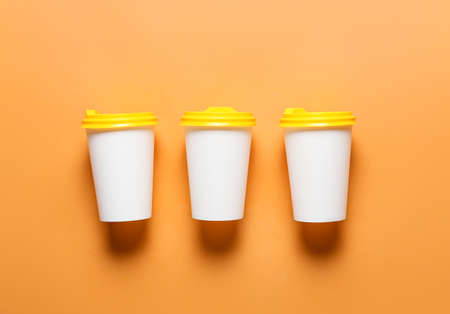 Takeaway cups for coffee on color backgroundの写真素材