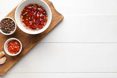 Board with hot honey and ingredients on light wooden backgroundの写真素材