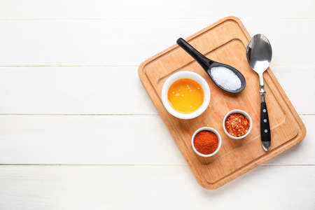 Board with honey and spices on light wooden backgroundの写真素材