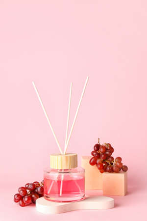 Reed diffuser with grapes on color background
