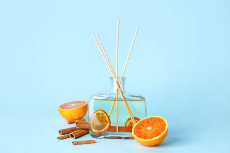 Reed diffuser with cinnamon and oranges on color backgroundの写真素材