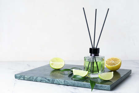 Reed diffuser with lemon and lime on light backgroundの写真素材