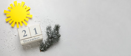 Calendar with date of winter solstice and sun on light background with space for text