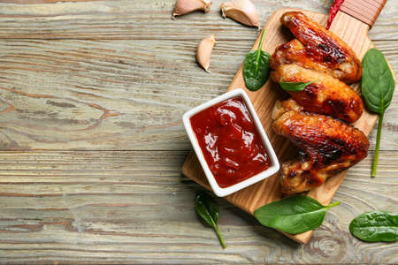 Roasted chicken wings and barbecue sauce on wooden backgroundの写真素材