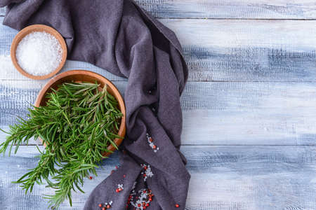 Composition with fresh rosemary and spices on wooden backgroundの写真素材