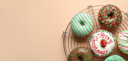 Grid with tasty Christmas donuts on light background with space for textの写真素材