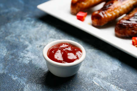 Roasted chicken wings and barbecue sauce on color backgroundの写真素材