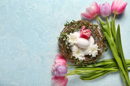 Composition with Easter eggs and spring flowers on color backgroundの写真素材