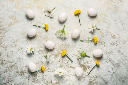 Composition with Easter eggs and spring flowers on light background