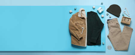 Set of children's clothes and calendar with date of Christmas on color background with space for textの写真素材
