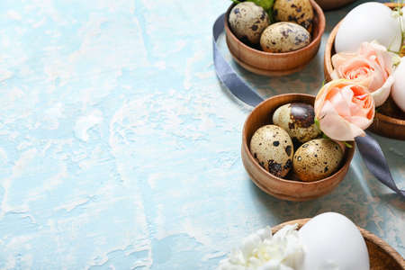 Composition with Easter eggs and spring flowers on color background