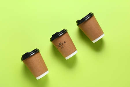 Blank paper cups with word COFFEE on color backgroundの写真素材