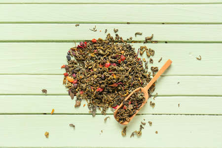 Dry green tea and scoop on color wooden backgroundの写真素材