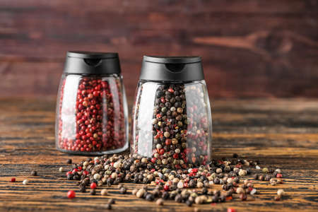 Jars with peppercorns on wooden backgroundの写真素材