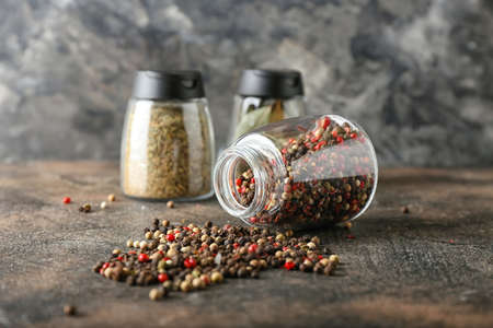 Overturned jar with mixed peppercorns on grunge backgroundの写真素材