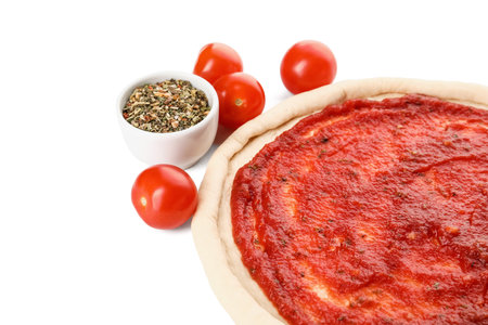 Pizza dough with tasty tomato sauce and spices on white backgroundの写真素材