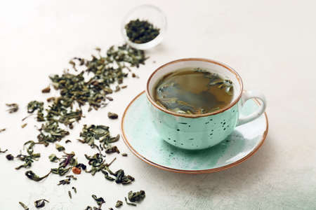 Cup of hot green tea on light backgroundの写真素材