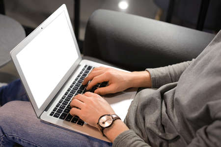 Handsome man using laptop at home late in eveningの写真素材