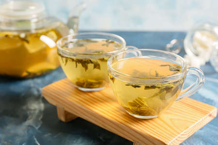 Stand with cups of green tea on color backgroundの写真素材