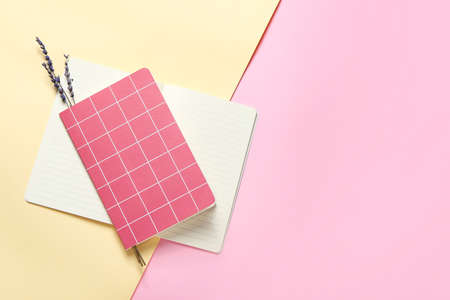 Notebooks and lavender flowers on color background