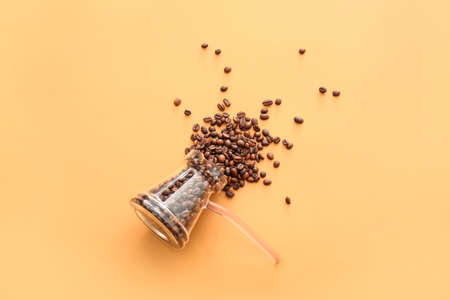 Cezve with coffee beans on color backgroundの写真素材