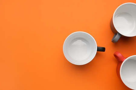 Empty cups on color background