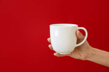 Hand with cup on color backgroundの写真素材