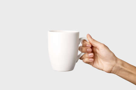 Hand with cup on light background