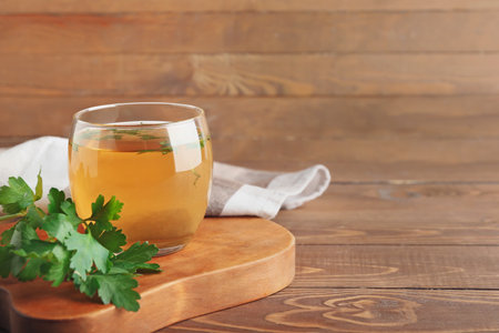 Cup of hot tea and parsley on wooden backgroundの写真素材