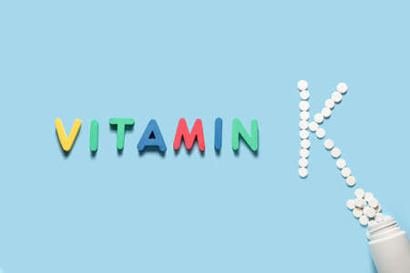 Word VITAMIN and letter K made of pills on color backgroundの写真素材