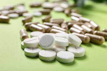 Different pills on color background, closeup