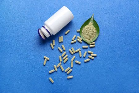 Bottle with pills and powder on color backgroundの写真素材