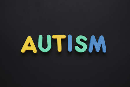 Word AUTISM on dark background
