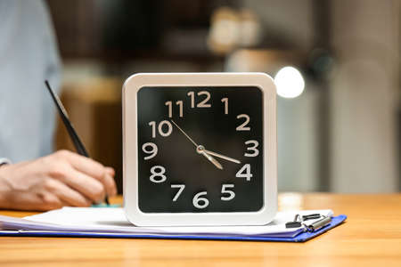 Clock with document on table in room