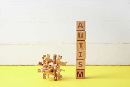 Word AUTISM and toy on color wooden backgroundの写真素材
