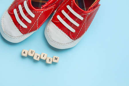 Word AUTISM and children's shoes on color backgroundの写真素材