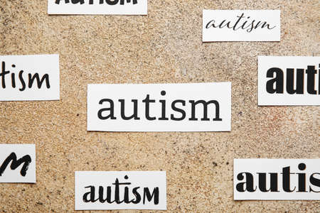 Pieces of paper with words AUTISM on grunge background, closeupの写真素材