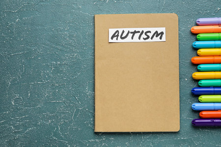 Notebook with word AUTISM and markers on grunge backgroundの写真素材
