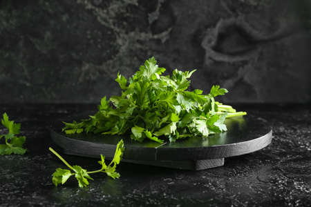 Board with fresh parsley on dark backgroundの写真素材