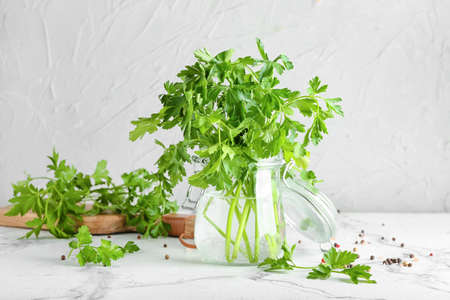 Jar with fresh parsley on light backgroundの写真素材