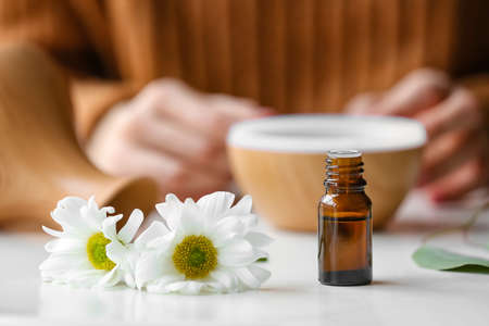 Bottle of chamomile essential oil on tableの写真素材