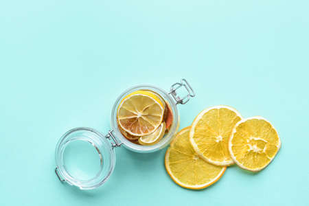 Jar with dried citrus fruits on color backgroundの写真素材