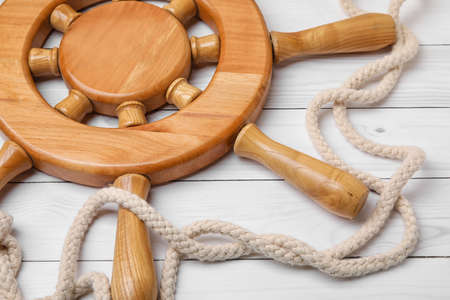 Helm and rope on white wooden background